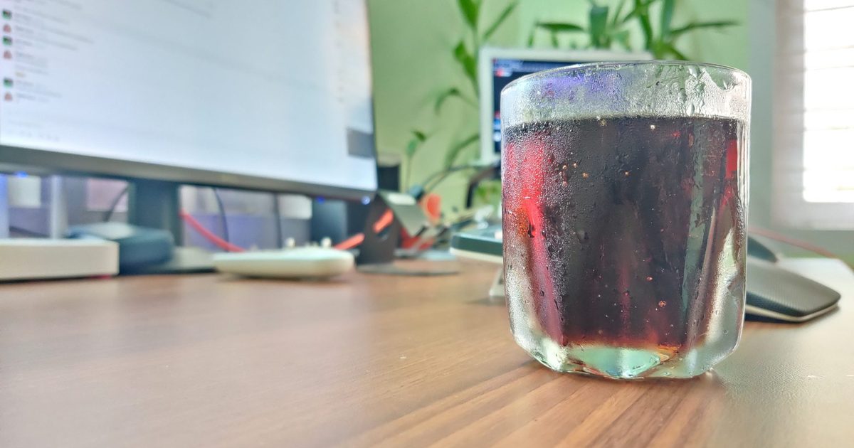 Iced drink on a wooden desk in a bright modern home workspace