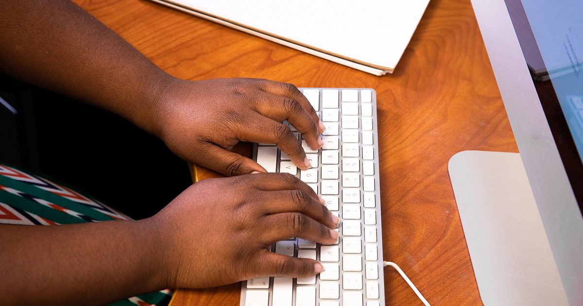 Close-up of hands typing on a keyboard